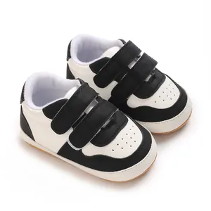 Close-up view of black and white baby walking shoes featuring soft non-slip rubber soles
