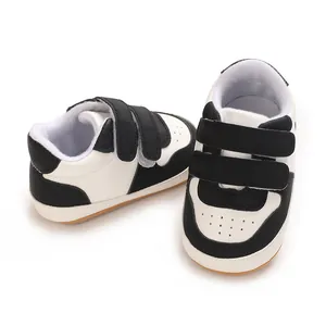Close-up of black and white baby walking shoes with soft non-slip rubber soles.