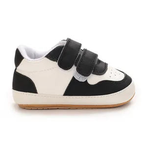 Toddler walking shoes with soft rubber sole and double hook-and-loop straps in white and black