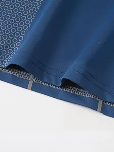 Detailed close-up of blue compression shirt hem showing fine stitching and reflective strips