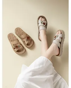 Detalle de sandalias de plataforma para mujer con adornos florales y tiras de cuero suave.