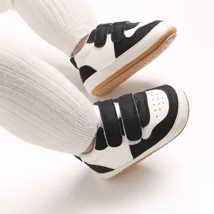 Detail view of black and white baby walking shoes with soft rubber soles and velcro straps