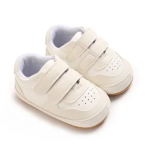 Soft white infant walking shoes with anti-slip rubber soles and double velcro straps