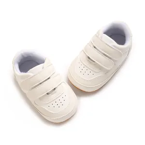Top view detail of white infant walking shoes featuring triple velcro straps for babies