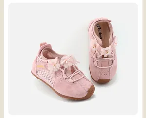 Close-up detail of girls' pink sneakers with decorative flowers and pearl accents