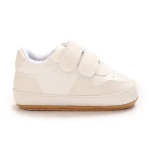 Side view of cream baby walking shoes with dual velcro straps and non-slip soft soles.
