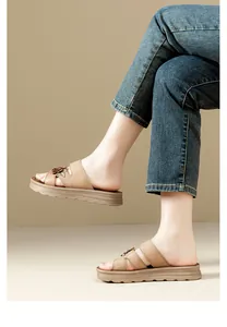Primer plano detallado de sandalias con plataforma marrón y decoración floral con vaqueros