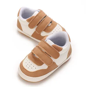 Close-up of brown and white infant walking shoes with soft soles and velcro straps