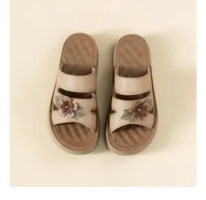 Vista detallada de sandalias de plataforma para mujer con cuero suave y decoración floral.