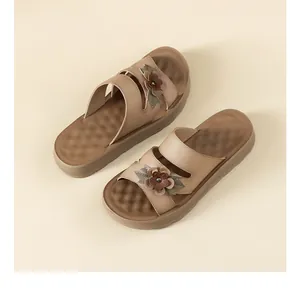 Detalle de sandalias de plataforma para mujer con elegante flor de cuero en marrón
