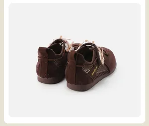 Back view detail of brown kids' soft-sole sneakers with bow accents and mesh