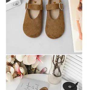 Nahaufnahme brauner Wildleder-Mary-Janes für Mädchen mit Metallschließe.