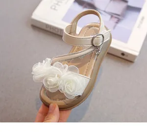 Nahaufnahme eleganter Kleinkind-Sandalen mit weißen Spitzenblumen und Strasssteinen
