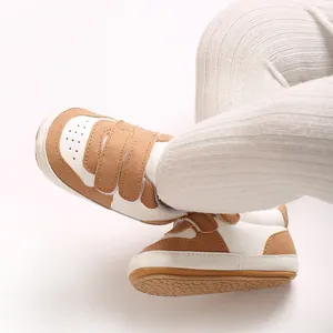 Close-up of brown and white baby walking shoes with soft non-slip soles and velcro straps