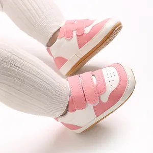 Detailed view of pink and white baby walker shoes with soft non-slip rubber soles.