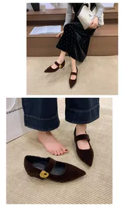 Detaillierte Nahaufnahme von braunen Samt-Mary-Jane-Pumps mit eleganter goldener Herzschnalle