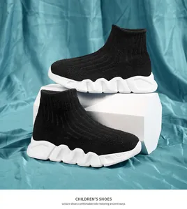Detalle de zapatillas de calcetín negras para niños con suelas blancas onduladas