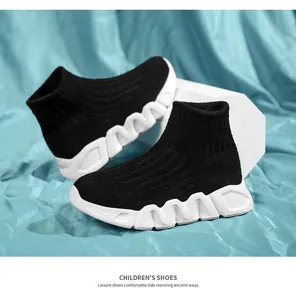 Primer plano de zapatillas tipo calcetín negras para niños con suela gruesa blanca