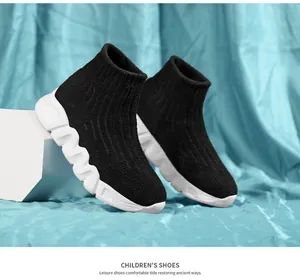 Vista detallada de las elegantes zapatillas calcetín negras para niños con suela blanca ondulada