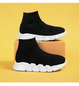 Vista de detalle de zapatillas tipo calcetín negras para niños con suela blanca.
