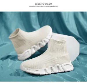 Vista detallada de zapatillas de calcetín crema para niños con suelas gruesas onduladas
