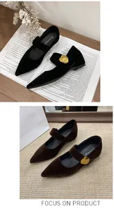 Detailansicht eleganter Mary Jane Schuhe mit spitzer Kappe und goldener Schnalle.