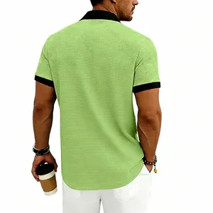 Détail d'un polo pour homme en maille gaufrée aux couleurs contrastées vert et noir