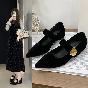 Nahaufnahme schwarzer Mary Jane Schuhe mit goldener Schnalle und verstecktem Absatz