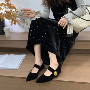 Elegante Frau in schwarzen spitzen Mary Jane Schuhen mit goldener Schnalle auf Holztreppe