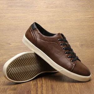 Close-up of men's brown leather casual shoes with non-slip wavy sole on wood background.
