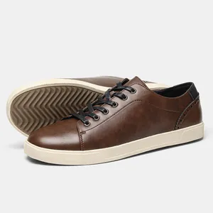 Detailed view of men's brown faux leather sneakers with black laces and cream sole