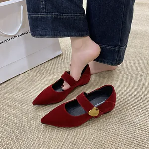Nahaufnahme von roten Mary Jane-Schuhen aus Samt mit eleganter goldener Schnalle