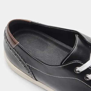 Nahaufnahme von klassischen Leder-Herrenschuhen mit Brogue-Mustern und Kontrastnähten.