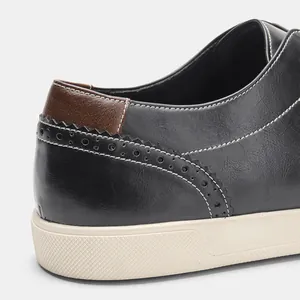 Close-up of heel detail on men's black leather casual sneakers with brogue stitching