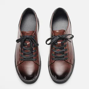 Detail view of premium brown men's casual leather sneakers featuring black laces and sole