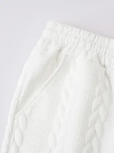 Macro detailopname van het witte jacquard breipatroon op een casual herenshort van katoen