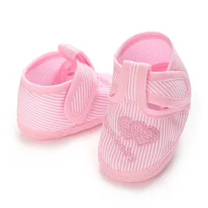 Vue détaillée des chaussures souples pour bébé à rayures roses avec motifs de cœurs.
