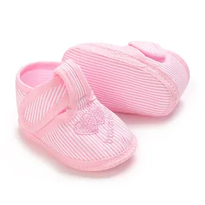 Vue détaillée de chaussures de bébé rayées roses avec broderie coeur et semelles souples