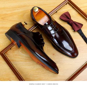 Detailed view of shiny burgundy patent leather men's dress shoes with professional props.