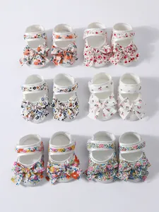 Detailansicht einer Vielzahl von geblümten Baby-Prinzessinnenschuhen mit großen Schleifen