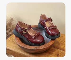 Vista dettagliata di scarpe Mary Jane bordeaux con fiocco e cinturino con fibbia