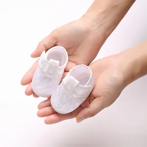 Gros plan détaillé de chaussures de baptême blanches à semelle souple pour bébé