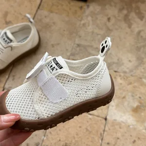 Gros plan sur des chaussures de marche bébé en maille blanche avec semelle en gomme