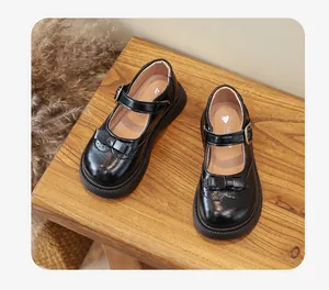 Eleganti scarpe Mary Jane nere per bambine con dettaglio a fiocco e suola in gomma robusta.