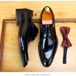 Detail of shiny black patent leather men's dress shoes with a formal burgundy bow tie.