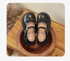 Vista dall'alto delle classiche scarpe Mary Jane nere per bambine con fiocco e cinturino