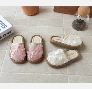 Vista detallada de pantuflas de princesa para niña rosa y blancas con encaje de rosas.