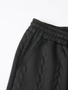 Detailopname van zwarte jacquard shorts met een elastische tailleband en zijzak