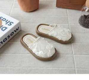 Detalle de las zapatillas de encaje crema para niñas con flores de rosa en 3D y suela.