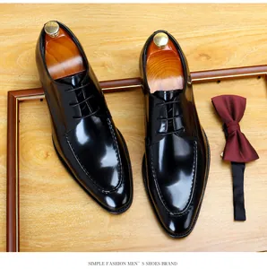 Detailed top-down view of shiny black patent leather men's formal shoes with wooden shoe trees